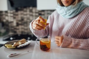 Close up photo,  female hands squeezing lemon to her tea